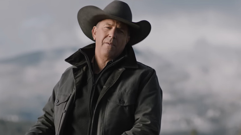 Kevin Costner's John Dutton sits on a horse against a blurry mountainous background in Yellowstone