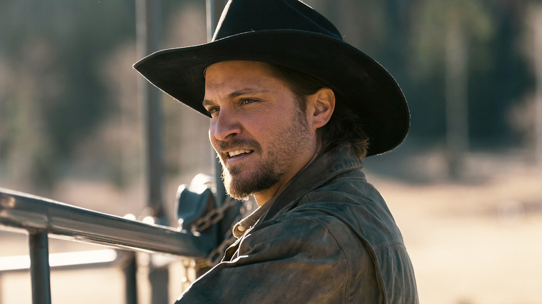 Luke Grimes' Kayce Dutton smiles as he leans on a fence in Marshals