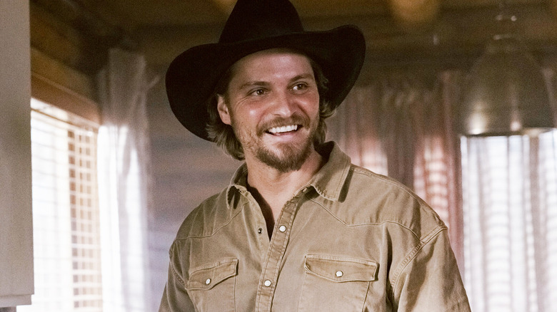 Luke Grimes' Kayce Dutton smiles as he stands in his home in Marshals