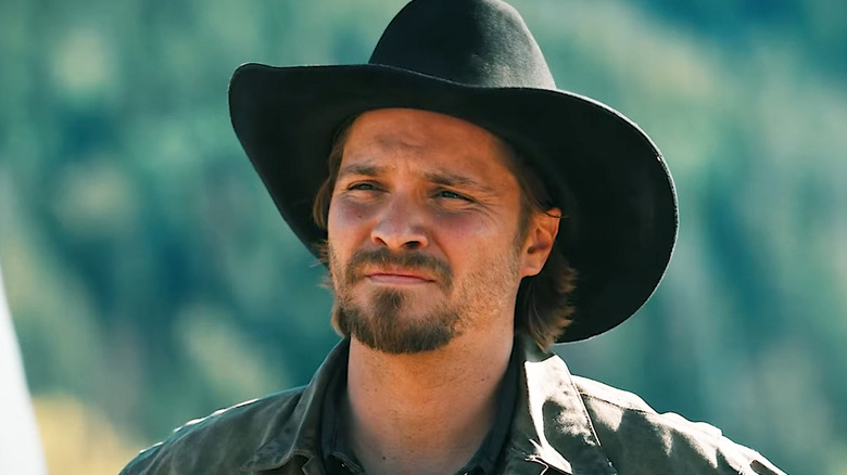 Luke Grimes' Kayce Dutton looks at someone standing off-screen as he stands outside on Marshals