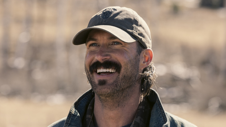 రిలే గ్రీన్ యొక్క గారెట్ మార్షల్స్‌లో దూరం వైపు చూస్తున్నప్పుడు నవ్వుతూ ఉంటాడు