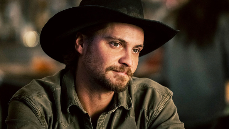 Luke Grimes' Kayce Dutton smiles as he sits in a bar in Marshals