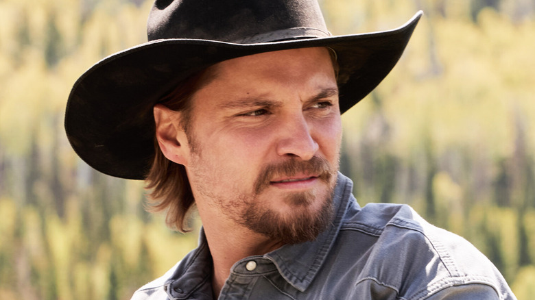 Luke Grimes's Kayce Dutton is seen in closeup against a blurry green background in Marshals