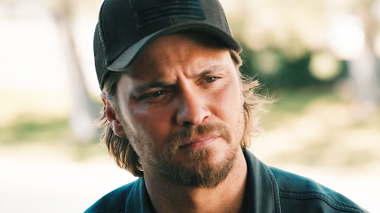 Luke Grimes' Kayce Dutton looks across frame as he stands outside in Marshals