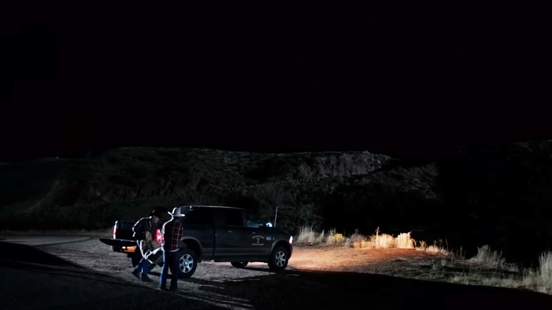 Forrie J. Smith's Lloyd Pierce and a helper carry a body from their truck at the train station in Yellowstone