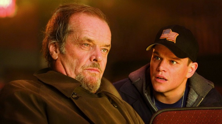 Matt Damon and Jack Nicholson sitting in a theater in The Departed