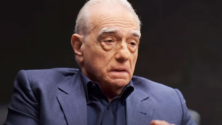 Martin Scorsese sits against a dark background during an interview