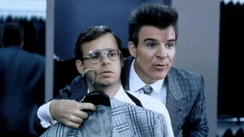 Vinnie holding up suit to Barney