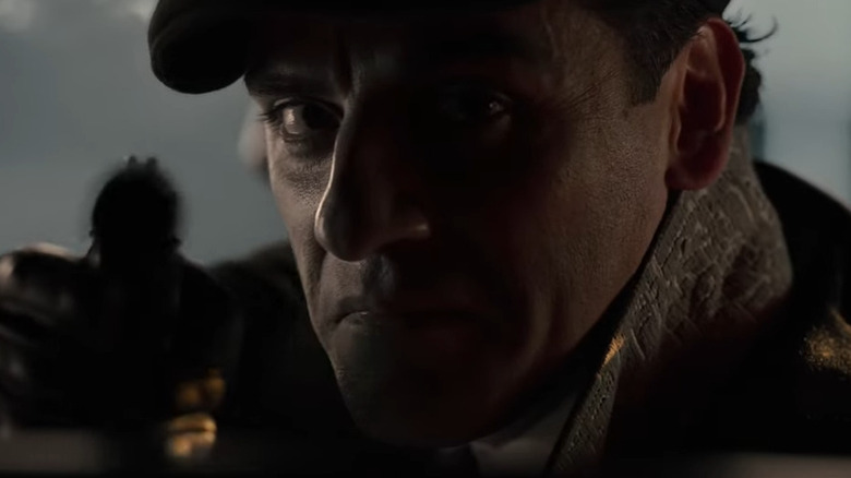 Oscar Isaac como Jake Lockley, apuntando a una pistola en el asiento del conductor en Moon Knight