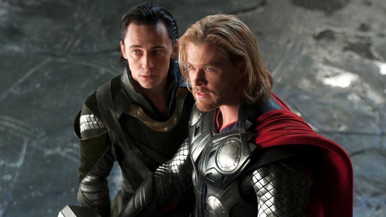 Loki (Tom Hiddleston) and Thor (Chris Hemsworth) stand together in Thor