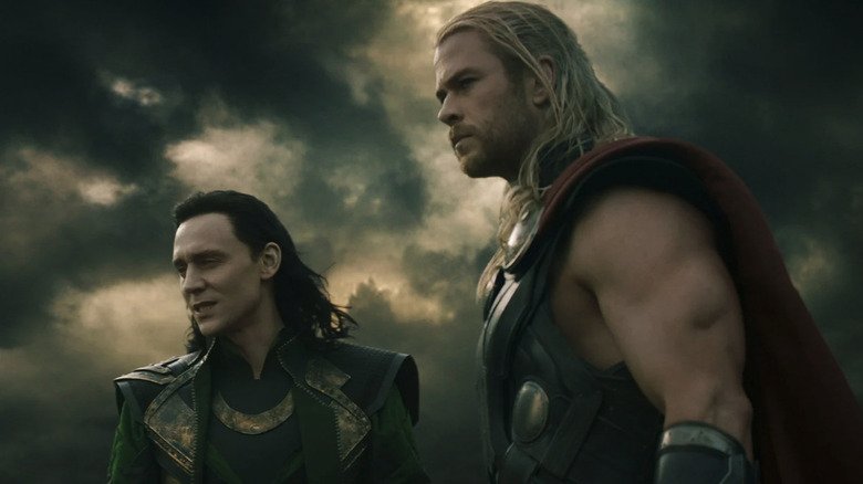 Thor (Chris Hemsworth) and Loki (Tom Hiddleston) stand in a cloudy setting in Thor: The Dark World