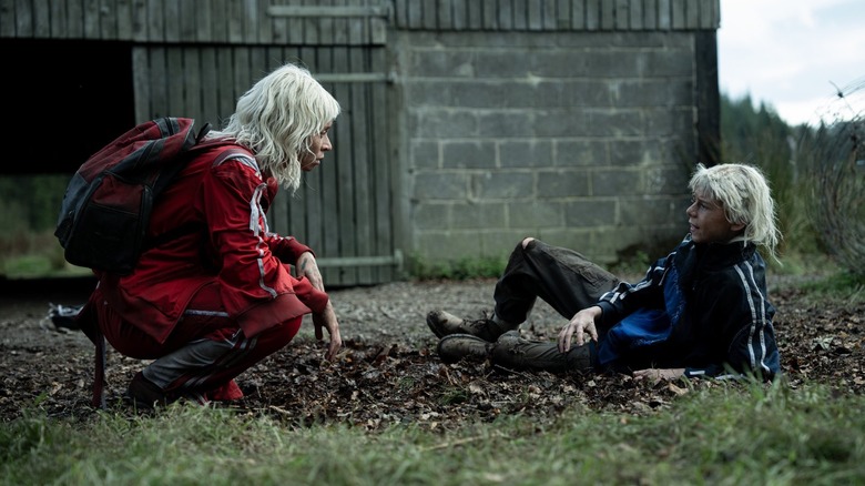 Erin Kellyman as Jimmy Ink kneeling on the ground next to Alfie Williams as Spike in 28 Years Later: The Bone Temple