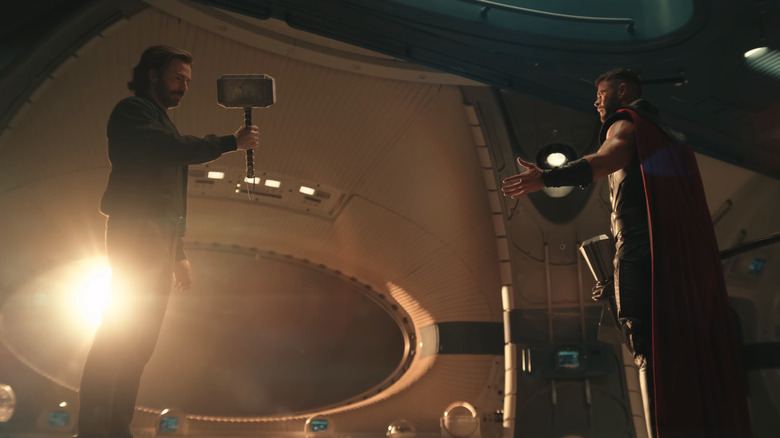 Chris Evans' Steve Rogers holds Mjölnir as he stands opposite Chris Hemsworth's Thor in Avengers: Doomsday