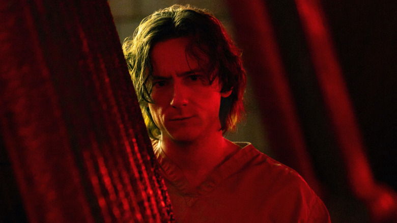 Bob Reynolds standing partially concealed in red lighting in Thunderbolts