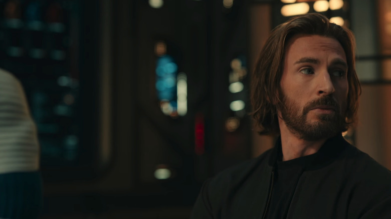 Chris Evans' Steve Rogers looks off to his left as he stands beside Ebon Moss-Bachrach's Ben Grimm in Avengers: Doomsday