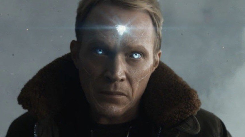 Paul Bettany as Vision standing in a room with chandeliers behind him next to James Spader as Ultron in VisionQuest