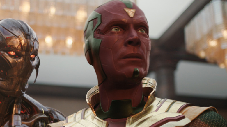 Paul Bettany as Vision standing in a room with chandeliers behind him next to James Spader as Ultron in VisionQuest