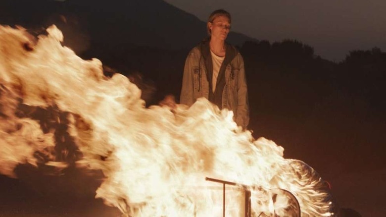 Michaela McManus as Irene in front of a burning man in a chair in Redux Redux