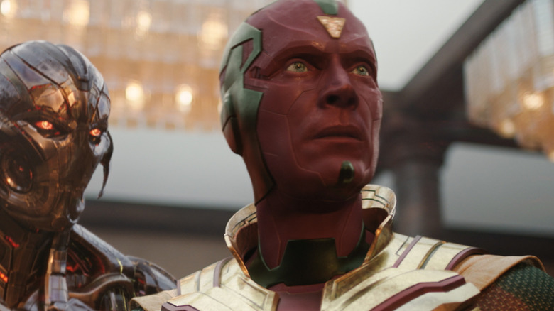 Paul Bettany as Vision standing in his superhero outfit next to James Spader as the voice of Ultron in VisionQuest