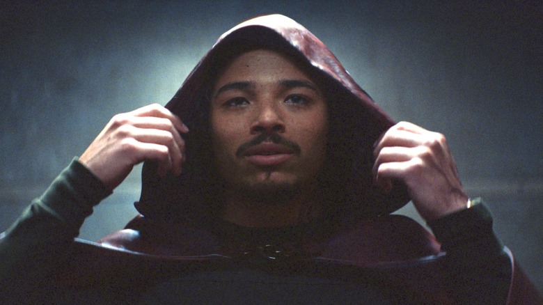 The Hood removing his hood