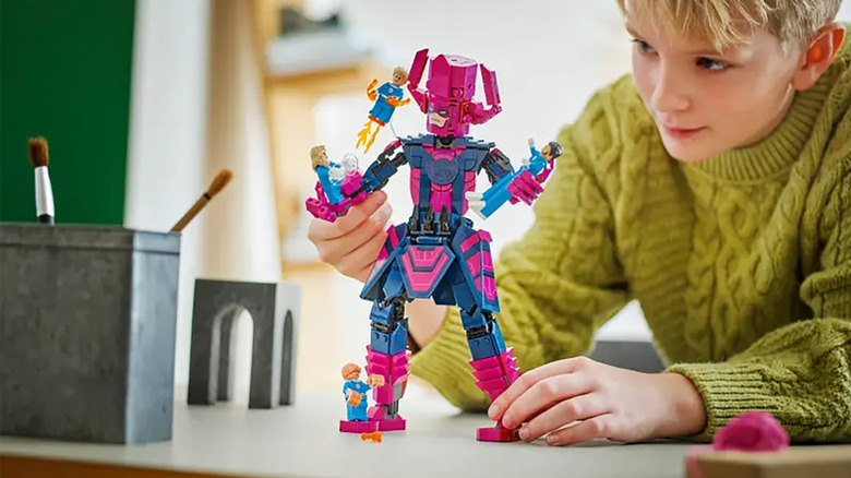 A boy plays with the Galactus vs Fantastic Four LEGO set