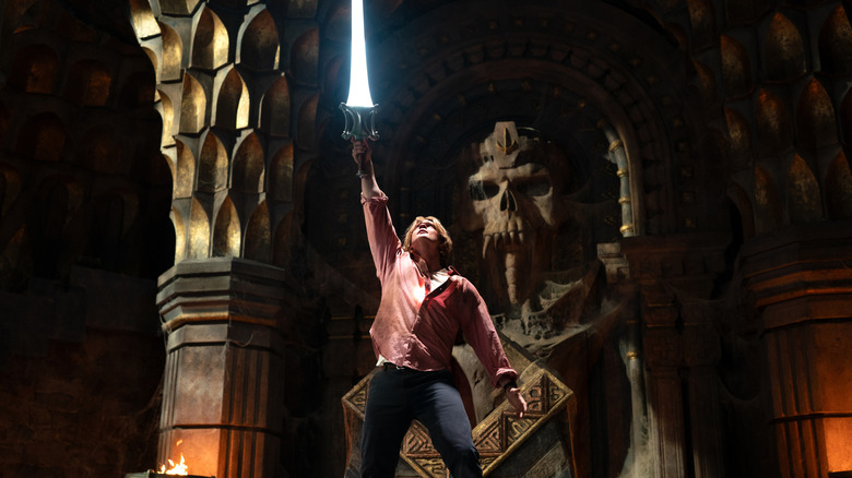 Prince Adam raising the Sword of Power inside castle Grayskull in Masters of the Universe