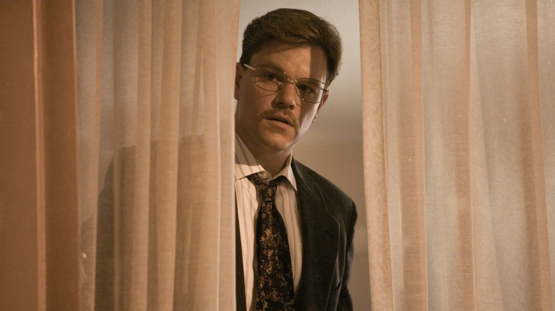 Matt Damon dans le rôle de Mark regardant derrière un rideau dans The Informant