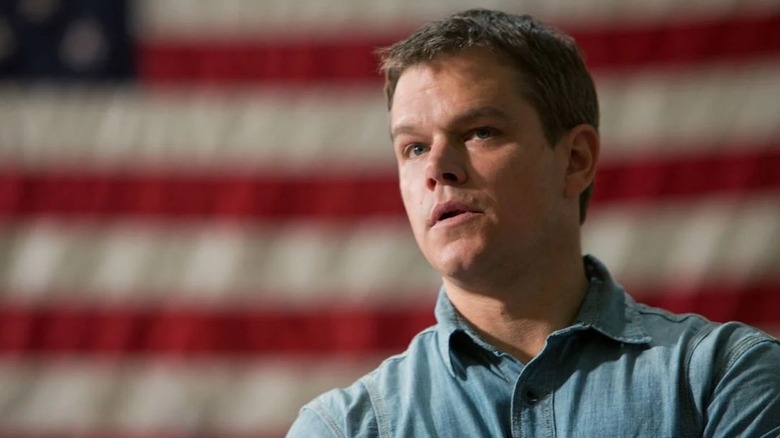 Matt Damon stands in front of a United States flag as Steve Butler in Promised Land