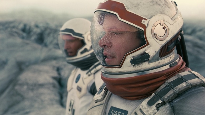 Matt Damon as Dr. Mann stands in a space suit alongside Matthew McConaughey as Joseph Cooper in Interstellar