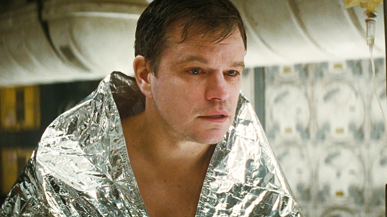 Matt Damon as Mann sits under a foil blanket in Interstellar