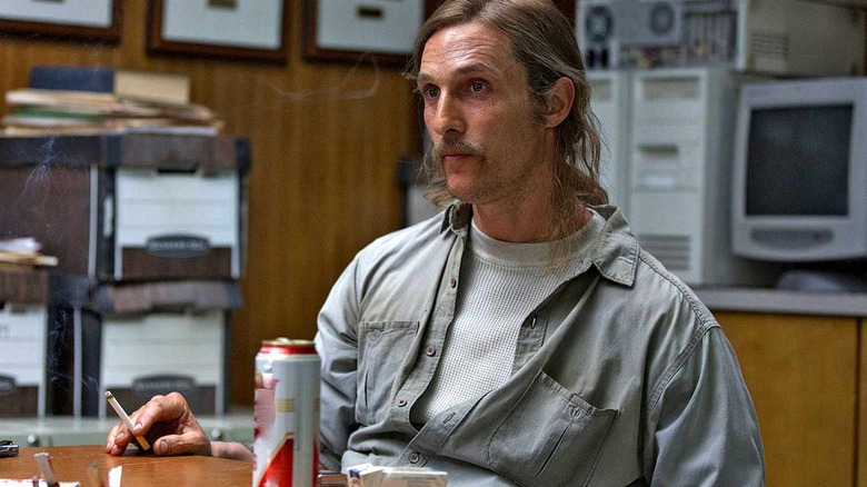 Rustin Cale sits at a cigarette table in his hand in a real detective