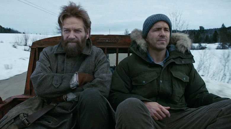 Nilokai (Kenneth Branagh) and Troy (Ryan Reynolds) sit in the back of a truck in Mayday