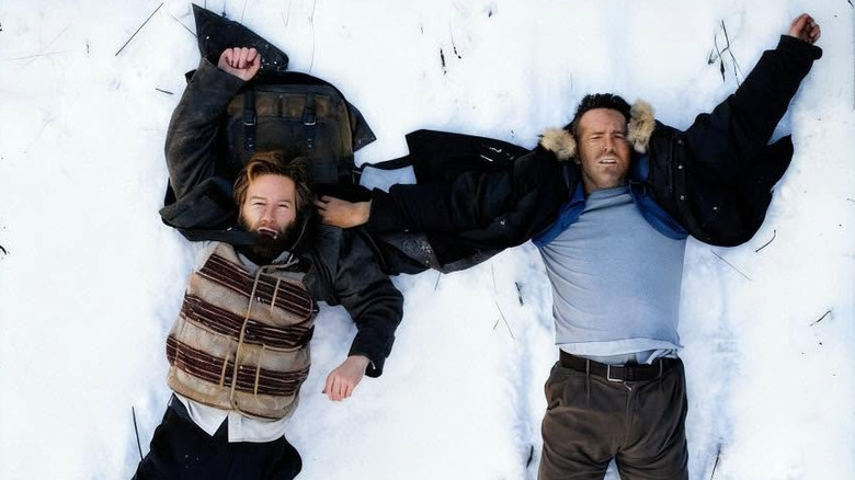 Nikolai (Kenneth Branagh) and Troy (Ryan Reynolds) lay in the snow in Mayday