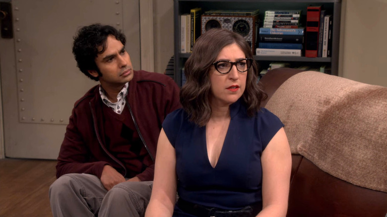 Amy is sitting on the sofa after she turned with Raj behind her on the theory of the big explosion