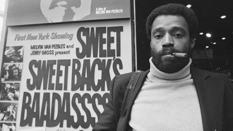 Melvin Van Peebles in front of an ad for Sweet Sweetback's Baadasssss Song