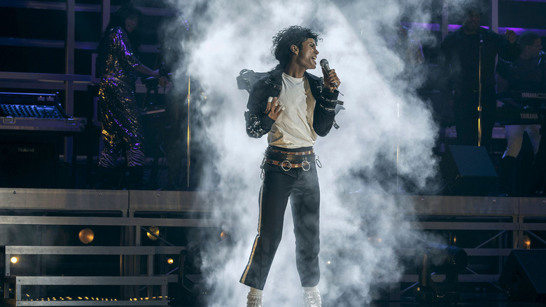 Jaafar Jackson as Michael Jackson singing on stage surrounded by fog in Michael (2026)