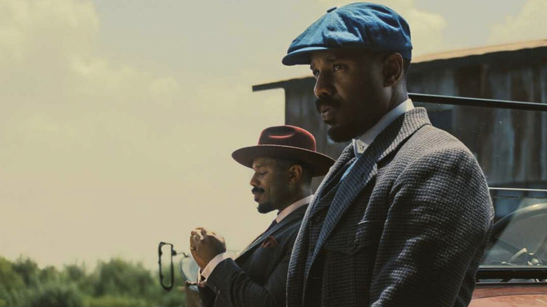 Smoke and Stack leaning against a car waiting for someone in Sinners