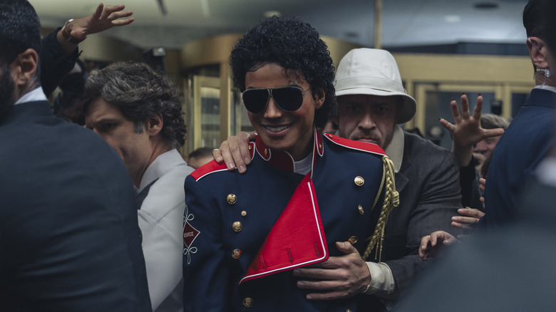 Michael Jackson smiles as he's hurried through a crowd of fans in Michael