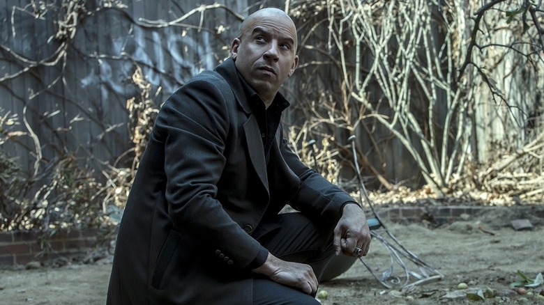 Vin Diesel as Kaulder kneeling in the woods in The Last Witch Hunter