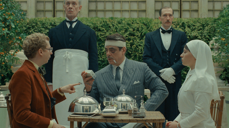Bjørn, Korda and Liesl sit down for a meal in The Phoenician Scheme
