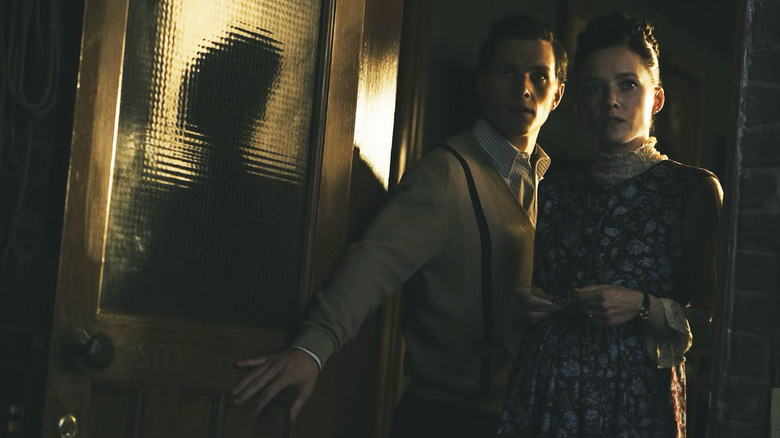 Young Ed and Lorraine Warren stand in a doorway in The Conjuring: Last Rites