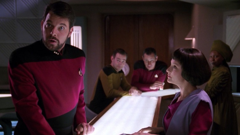 Riker, looking shocked in Ten-Forward, with Lal tending bar. An episode of Star Trek: The Next Generation.