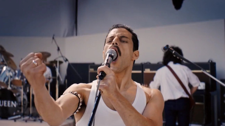 Rami Malek as Freddie Mercury singing on stage in Bohemian Rhapsody