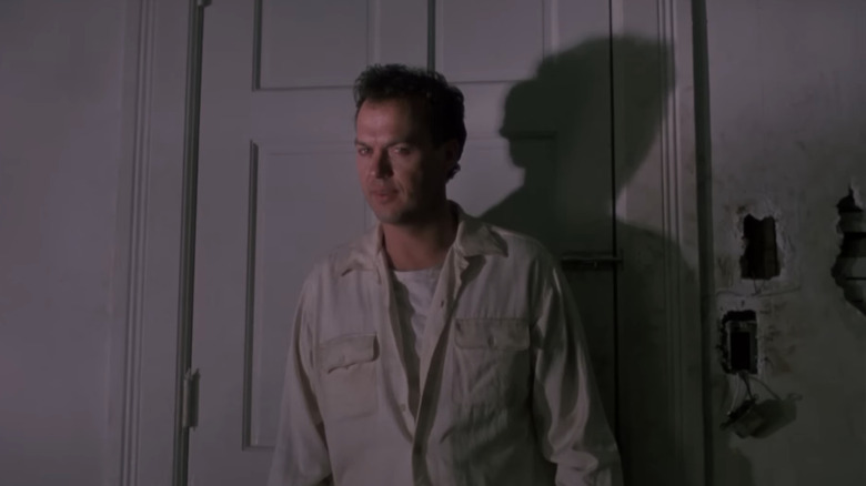 Michael Keaton's Carter Hayes stands in front of a closed door in Pacific Heights