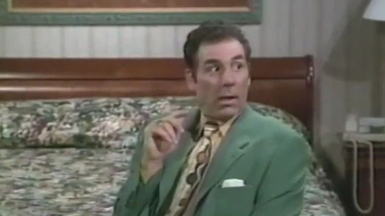 Vick Nardos in a green suit in the sanatorium on the show Michael Richards.