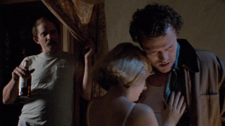 Tracy Arnold's Becky embracing Michael Rooker's Henry as her brother looks on iin Henry: Portrait of a Serial Killer