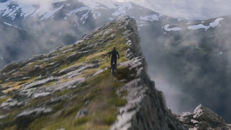 Ethan Hunt (Tom Cruise) riding a motorcycle off a mountain in Mission: Impossible - Dead Reckoning Part One