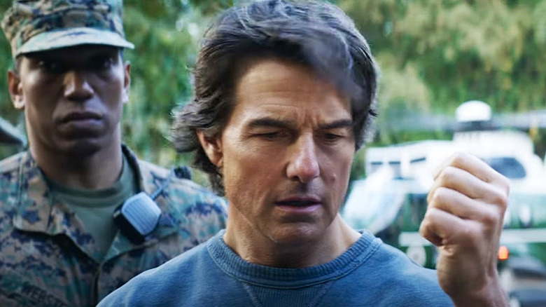 Ethan Hunt holds up his hand while a soldier stands behind him in Mission: Impossible – The Final Reckoning