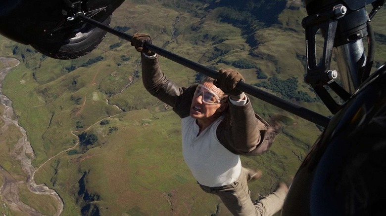 Ethan Hunt (Tom Cruise) hanging on the bottom of the two schemes