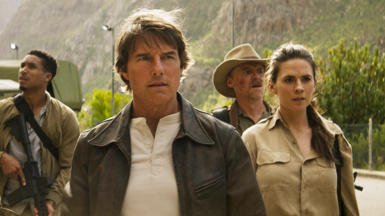 Degas (Greg Tarzan Davis), Ethan (Tom Cruise), Bani (Simon Beige) and Ris (Hayley Atwell) stands in front of a truck and walks on the road